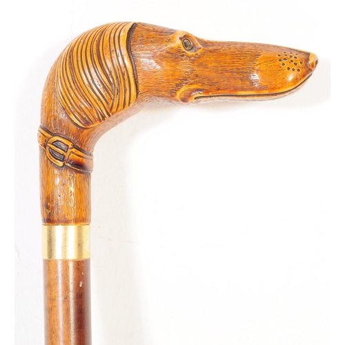 363 - A 20th century walking stick having handle carved in the from of a dogs head with amber glass bead e... 