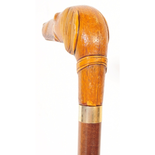 363 - A 20th century walking stick having handle carved in the from of a dogs head with amber glass bead e... 