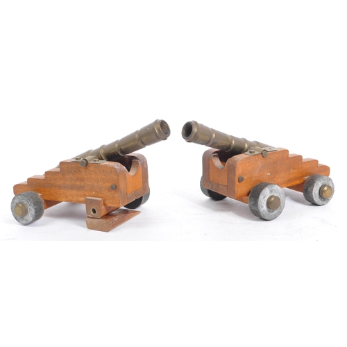 405a - A pair of early 20th century wooden and brass desk top cannons. Each with wooden carriages having br... 