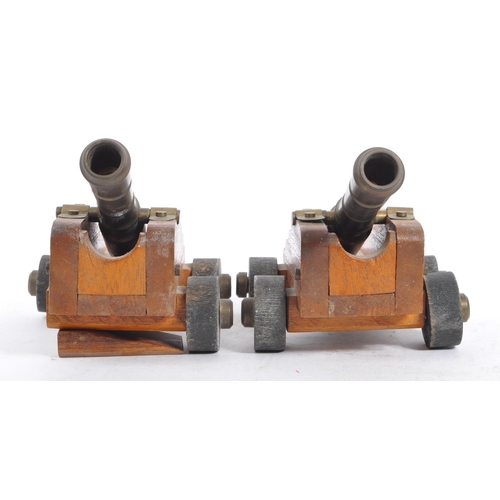 405a - A pair of early 20th century wooden and brass desk top cannons. Each with wooden carriages having br... 