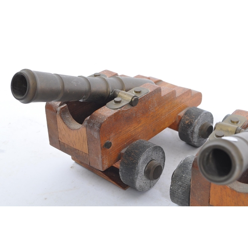 405a - A pair of early 20th century wooden and brass desk top cannons. Each with wooden carriages having br... 