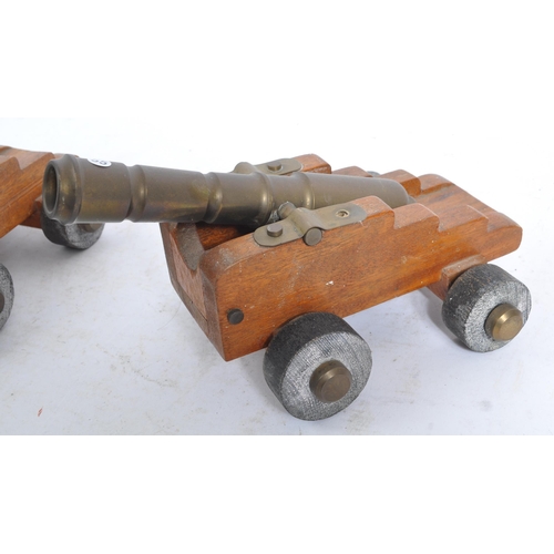 405a - A pair of early 20th century wooden and brass desk top cannons. Each with wooden carriages having br... 