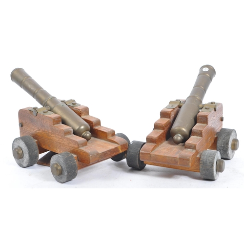 405a - A pair of early 20th century wooden and brass desk top cannons. Each with wooden carriages having br... 