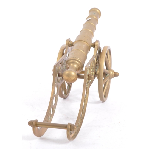 410a - A large early 20th century brass desk top cannon. The brass cannon set over a brass carriage with la... 