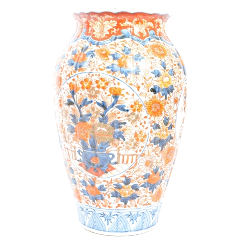 89 - A pair of late 19th century Japanese Imari urn vases. The vases featuring blue and red floral motifs... 