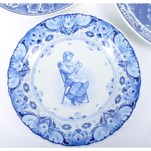 93 - Three early 20th century continental delftware blue & white chargers, to include one featuring a you... 