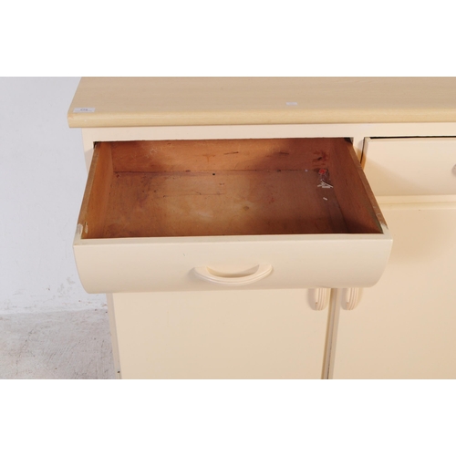 574 - Remploy - A retro mid 20th century Remploy cream kitchen unit / sideboard. The sideboard having cant... 