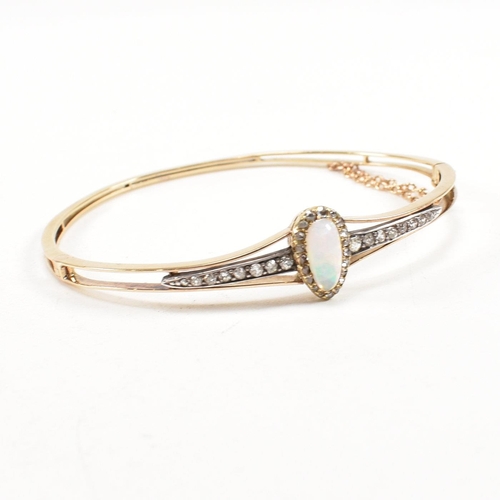 10 - A cased early late Victorian Edwardian opal and diamond hinged bangle. The bangle having a pear cut ... 