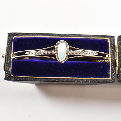 10 - A cased early late Victorian Edwardian opal and diamond hinged bangle. The bangle having a pear cut ... 