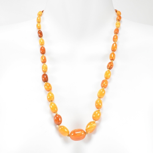 19 - A 1930S butterscotch amber bead necklace. The necklace strung with graduating beads from 2.2cm to 7m... 