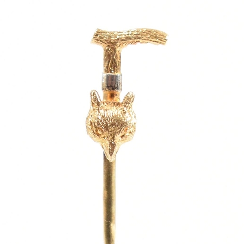 42 - An 18ct gold riding interest tie pin. The novelty pin in the form of a riding crop with a foxes head... 