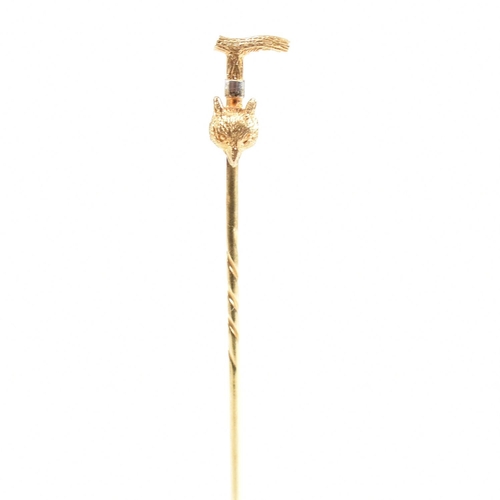 42 - An 18ct gold riding interest tie pin. The novelty pin in the form of a riding crop with a foxes head... 