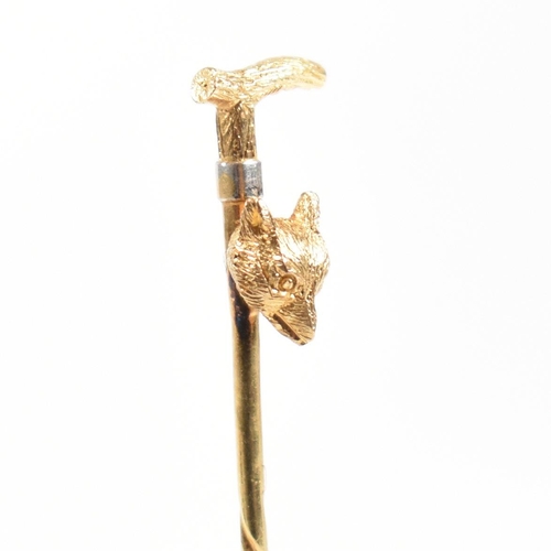 42 - An 18ct gold riding interest tie pin. The novelty pin in the form of a riding crop with a foxes head... 