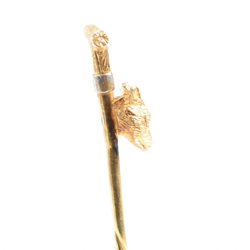 42 - An 18ct gold riding interest tie pin. The novelty pin in the form of a riding crop with a foxes head... 