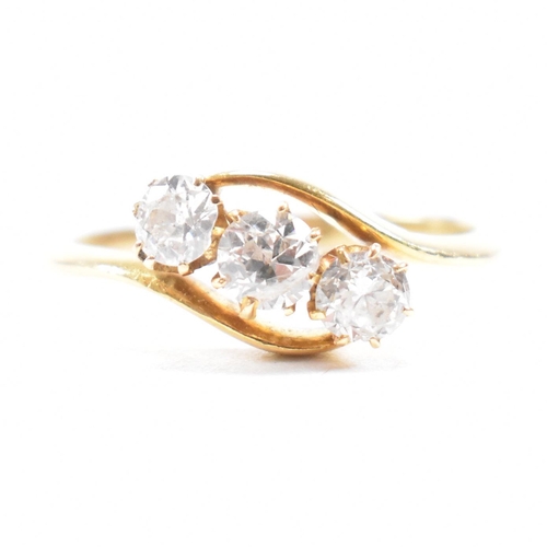 553 - A hallmarked 18ct gold and diamond three stone ring. The crossover ring being set with three graduat... 