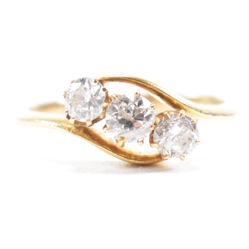 553 - A hallmarked 18ct gold and diamond three stone ring. The crossover ring being set with three graduat... 