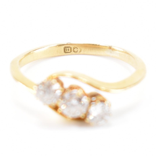 553 - A hallmarked 18ct gold and diamond three stone ring. The crossover ring being set with three graduat... 