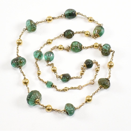 58 - A gold and carved emerald bead necklace. The necklace strung with 15 carved emerald beads having gol... 