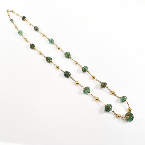 58 - A gold and carved emerald bead necklace. The necklace strung with 15 carved emerald beads having gol... 