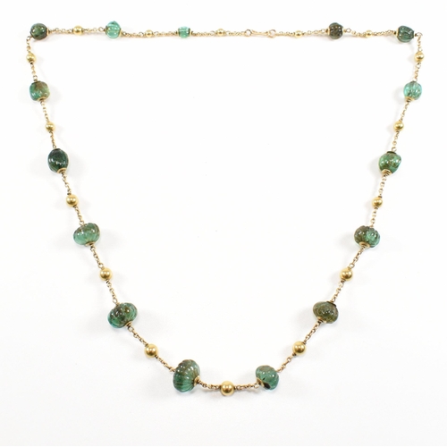 58 - A gold and carved emerald bead necklace. The necklace strung with 15 carved emerald beads having gol... 