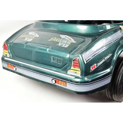 394 - An Italian made Jaguar V12 pedal car. Green plastic body with integrated seat, grey steering wheel a... 