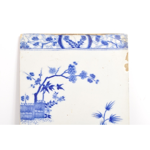 100 - A 19th Century ceramic Chinese tile in blue and white depicting a blossom tree and other foliage, wi... 