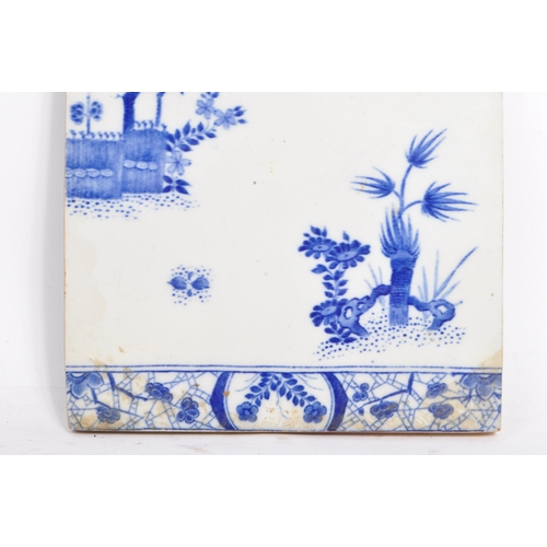 100 - A 19th Century ceramic Chinese tile in blue and white depicting a blossom tree and other foliage, wi... 