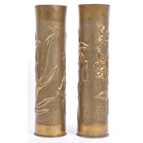 218 - A pair of early 20th century circa WWI hammered brass trench art vases. Each being of cylindrical fo... 