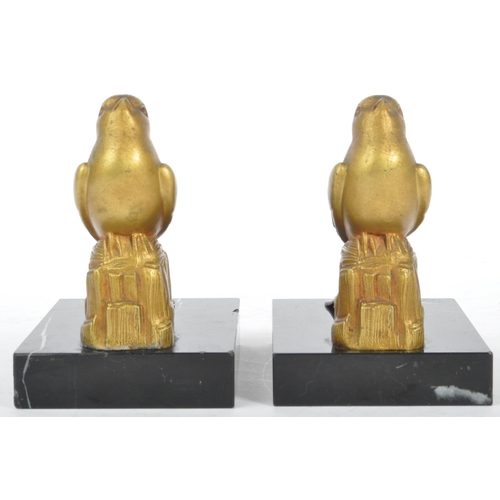 219 - A pair of 20th century Art Deco gilt metal and marble bookends. Each having gilt metal bird finial a... 