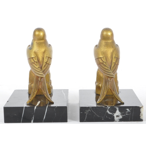 219 - A pair of 20th century Art Deco gilt metal and marble bookends. Each having gilt metal bird finial a... 