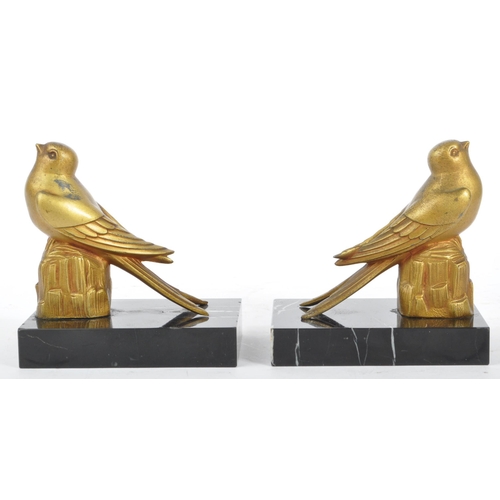 219 - A pair of 20th century Art Deco gilt metal and marble bookends. Each having gilt metal bird finial a... 