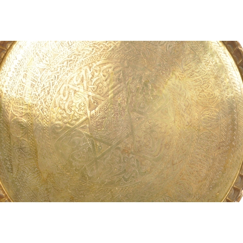 228 - A large 20th century Islamic Middle Eastern engraved brass tray wall charger. The tray having Islami... 