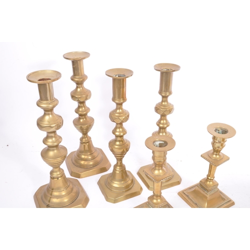 275 - A collection of late 19th / early 20th century brass candlesticks and jam pot. To include three matc... 