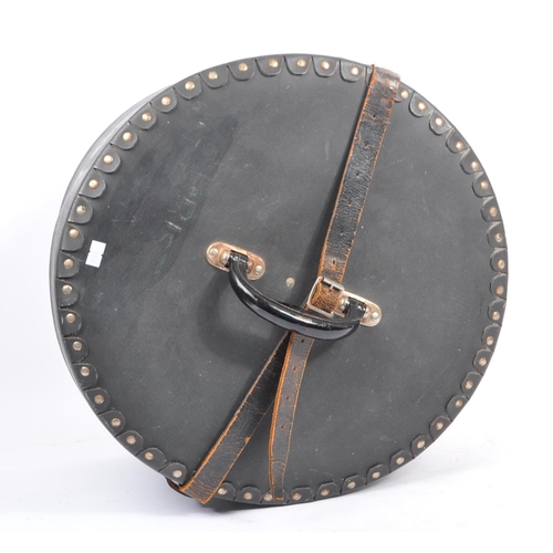 279 - A retro 1980's circular travel box / hat case with carry handle and leather closure strap. Measures ... 