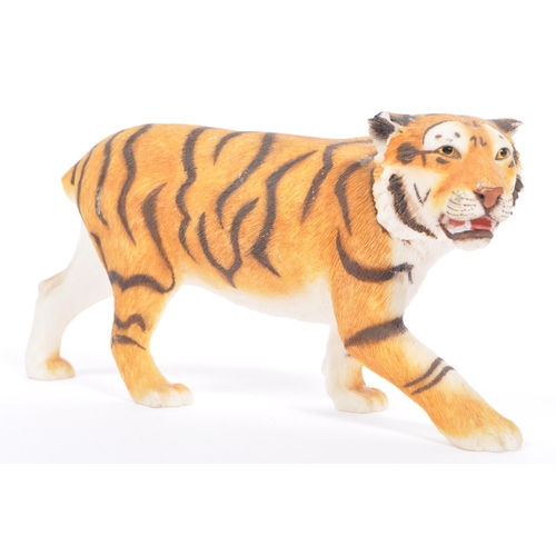 313 - A group of four resin 'tiger' figurines of the animal kingdom. To include two prowling tigers, playf... 