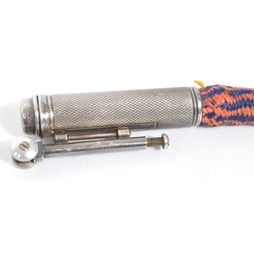 321 - A 1920's Flamidor Ouragan rope lighter. The lighter having engine turned decoration with blank carto... 