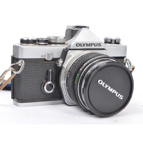 328 - A 20th century circa 1970s Olympus OM-1 MD 35mm SLR camera and lenses. The camera having a metal bod... 