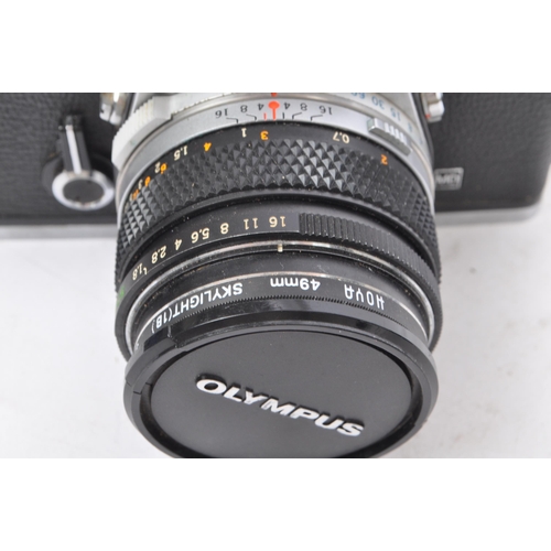 328 - A 20th century circa 1970s Olympus OM-1 MD 35mm SLR camera and lenses. The camera having a metal bod... 