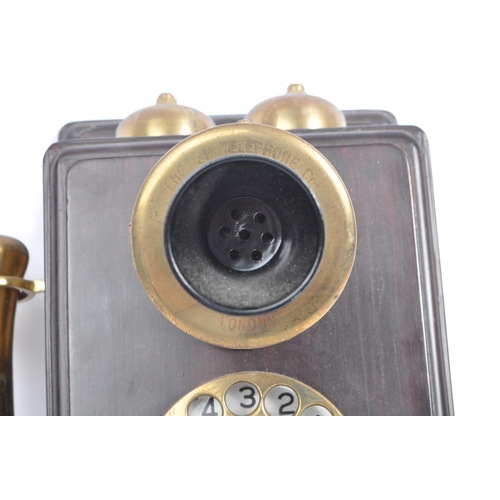 356 - An early 20th century circa 1930s wall hanging telephone. The telephone having a mahogany wooden cas... 