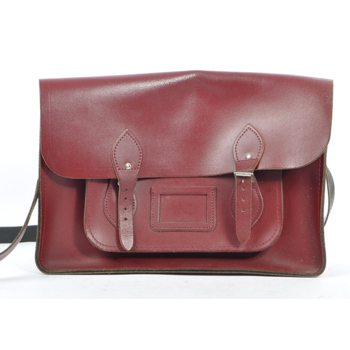 358 - A cherry red leather satchel by The Cambridge Satchel Company. With red stitching, shoulder strap an... 