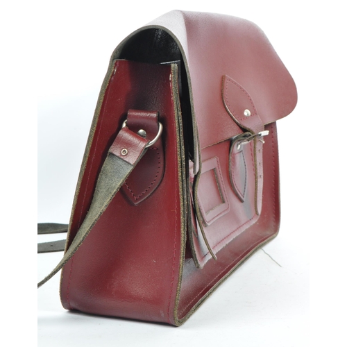 358 - A cherry red leather satchel by The Cambridge Satchel Company. With red stitching, shoulder strap an... 