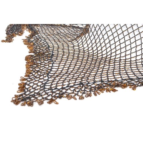 363 - A vintage 1970s art deco style knitted net shawl embellished with orange/brown beads and crochet bor... 