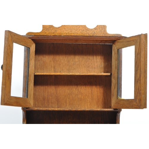 231 - An early 20th century oak apprentice piece Welsh dresser cabinet. With a carved pediment top, into t... 