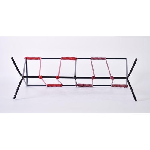 185 - A mid 20th century vintage sputnik atomic ebonised wire magazine rack. The rack having wrapped plast... 