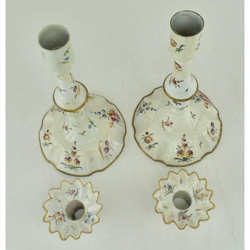 157 - A pair of mid 18th century c1765 Bilston enamel candlesticks, along with one other. The pair with pe... 