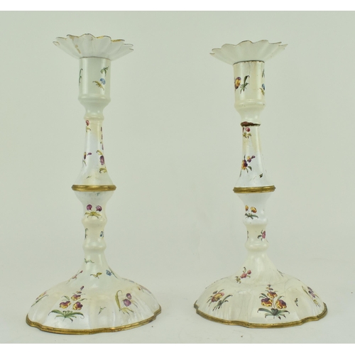 157 - A pair of mid 18th century c1765 Bilston enamel candlesticks, along with one other. The pair with pe... 