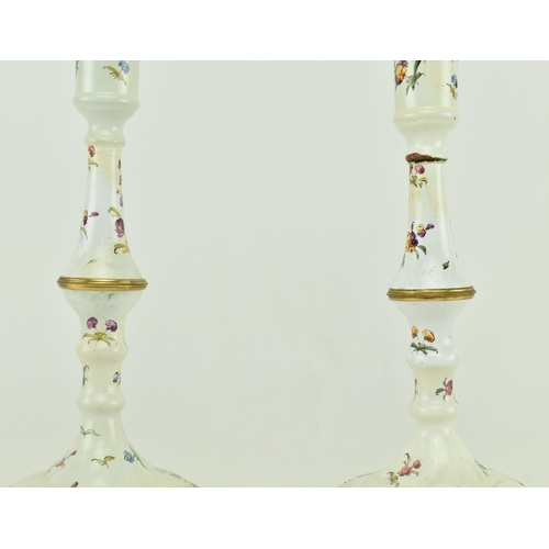 157 - A pair of mid 18th century c1765 Bilston enamel candlesticks, along with one other. The pair with pe... 