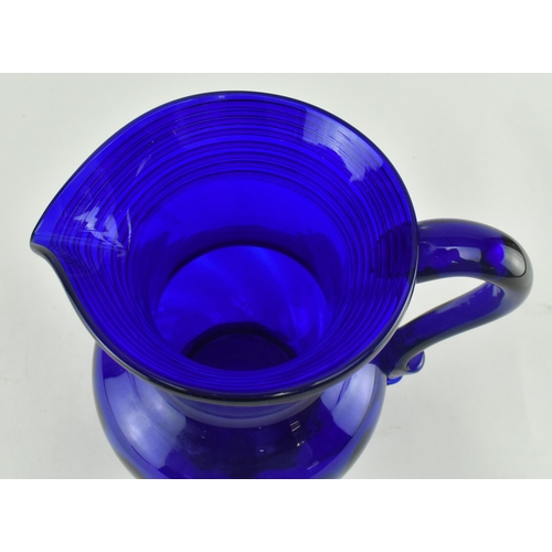 172 - An early-mid 19th century cobalt blue glass water jug. The jug with trailed design around the flared... 