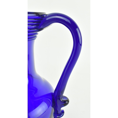 172 - An early-mid 19th century cobalt blue glass water jug. The jug with trailed design around the flared... 