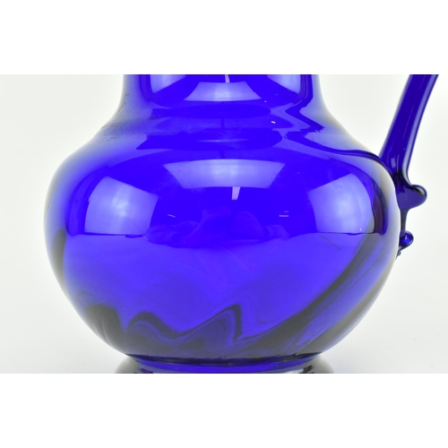 172 - An early-mid 19th century cobalt blue glass water jug. The jug with trailed design around the flared... 